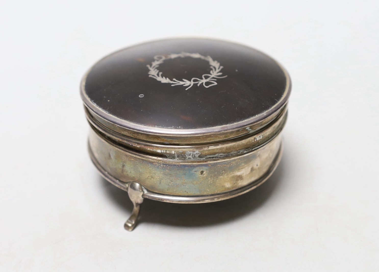 A George V silver mounted tortoiseshell circular trinket box, Horton & Allday, Birmingham 1919, 81mm, together with a pair of mid 18th century silver sugar nips.